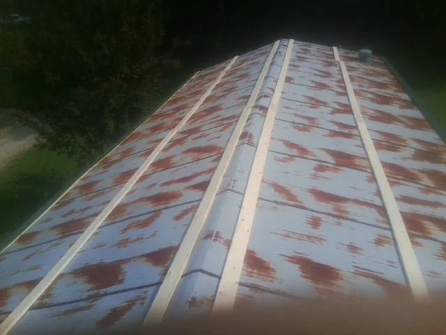 Rusted metal roof panels with new wood purlins before replacement — Storm Damage Roof Repair in Salvisa by Roofing Brothers