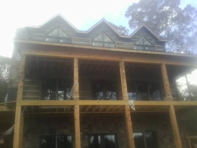 Dormers and porch framing on a large log home under construction — Roof Coating work by our crew in Salvisa