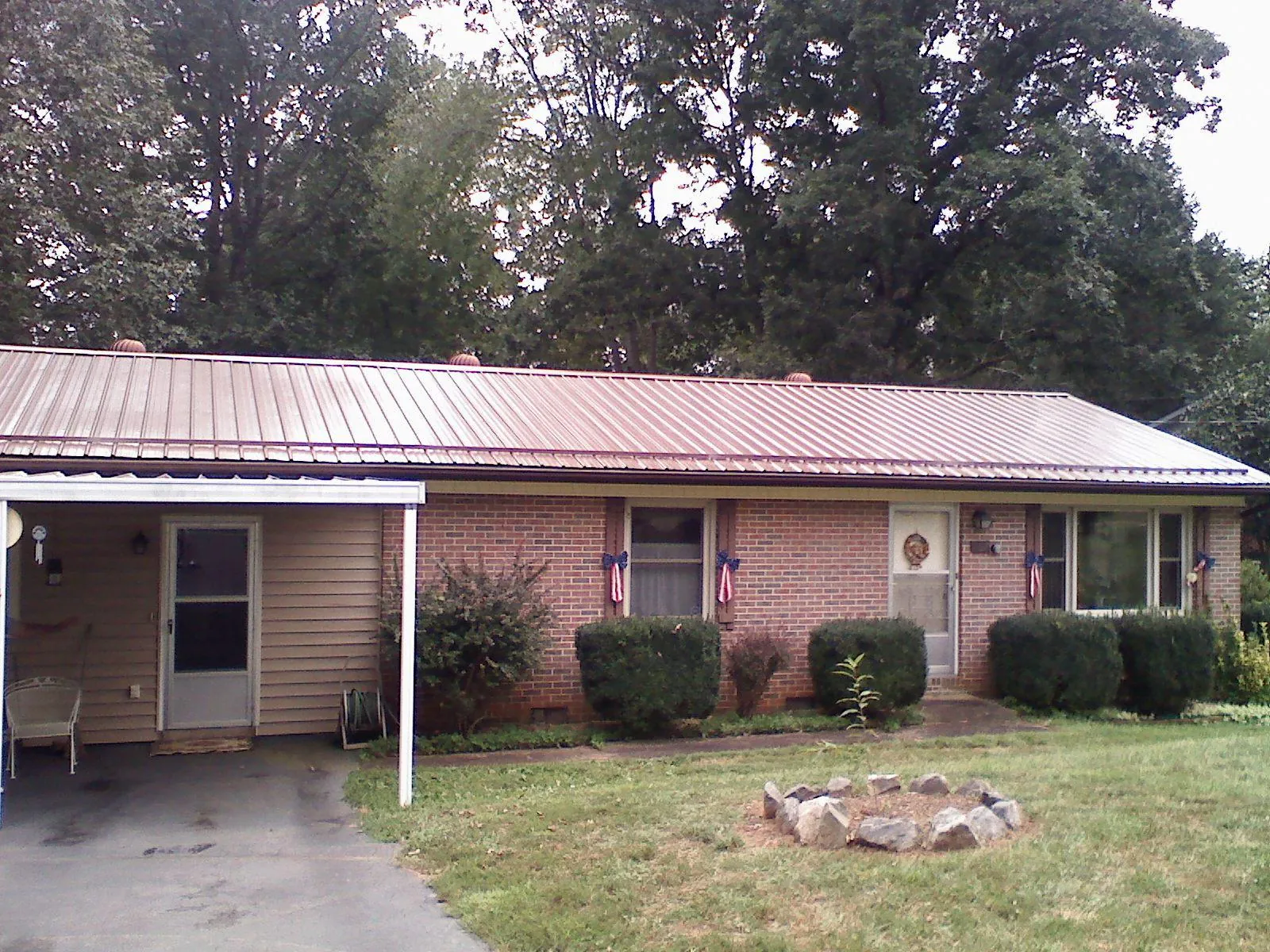Bronze metal roof and carport on a brick ranch home — Roof Repair work by our crew in Salvisa